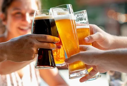 Guests raising beers at Saucy Brew Works