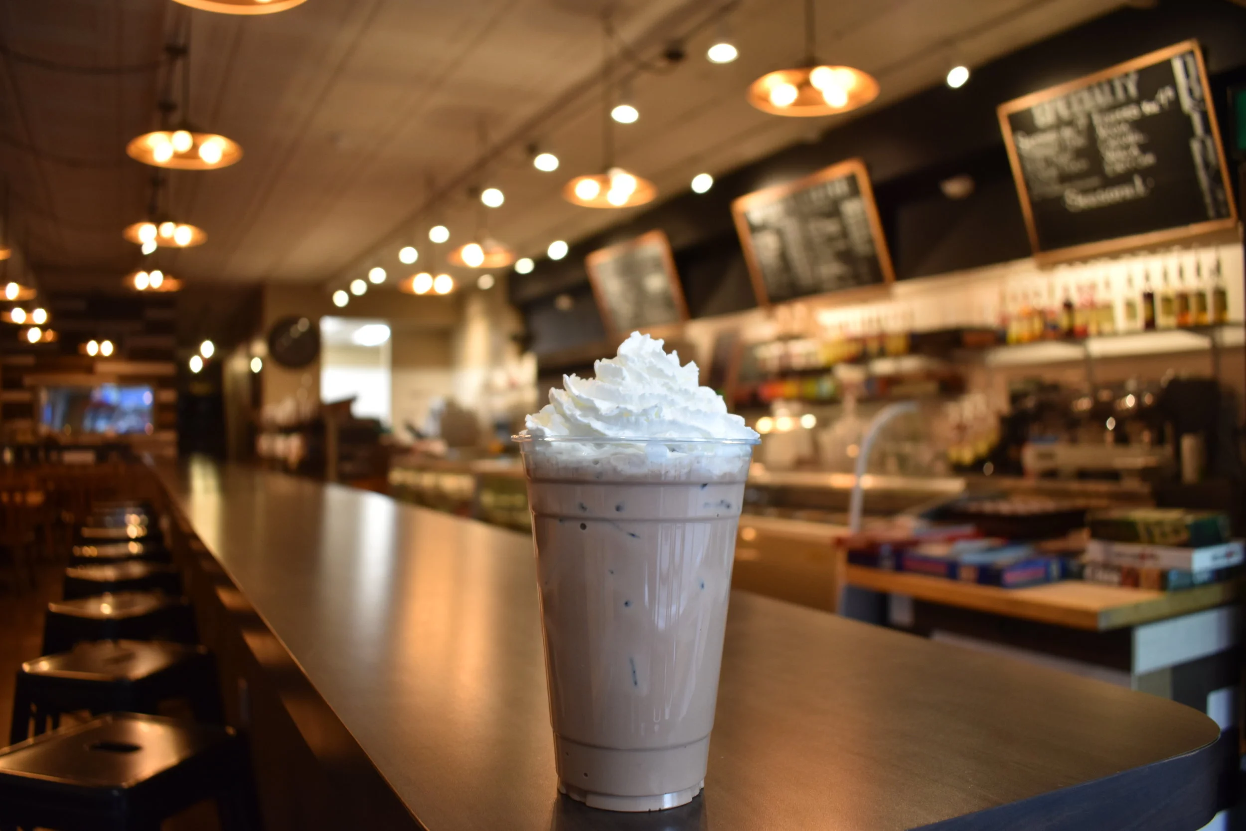 Whipped-cream-topped coffee drink at the Arabica Coffee House counter