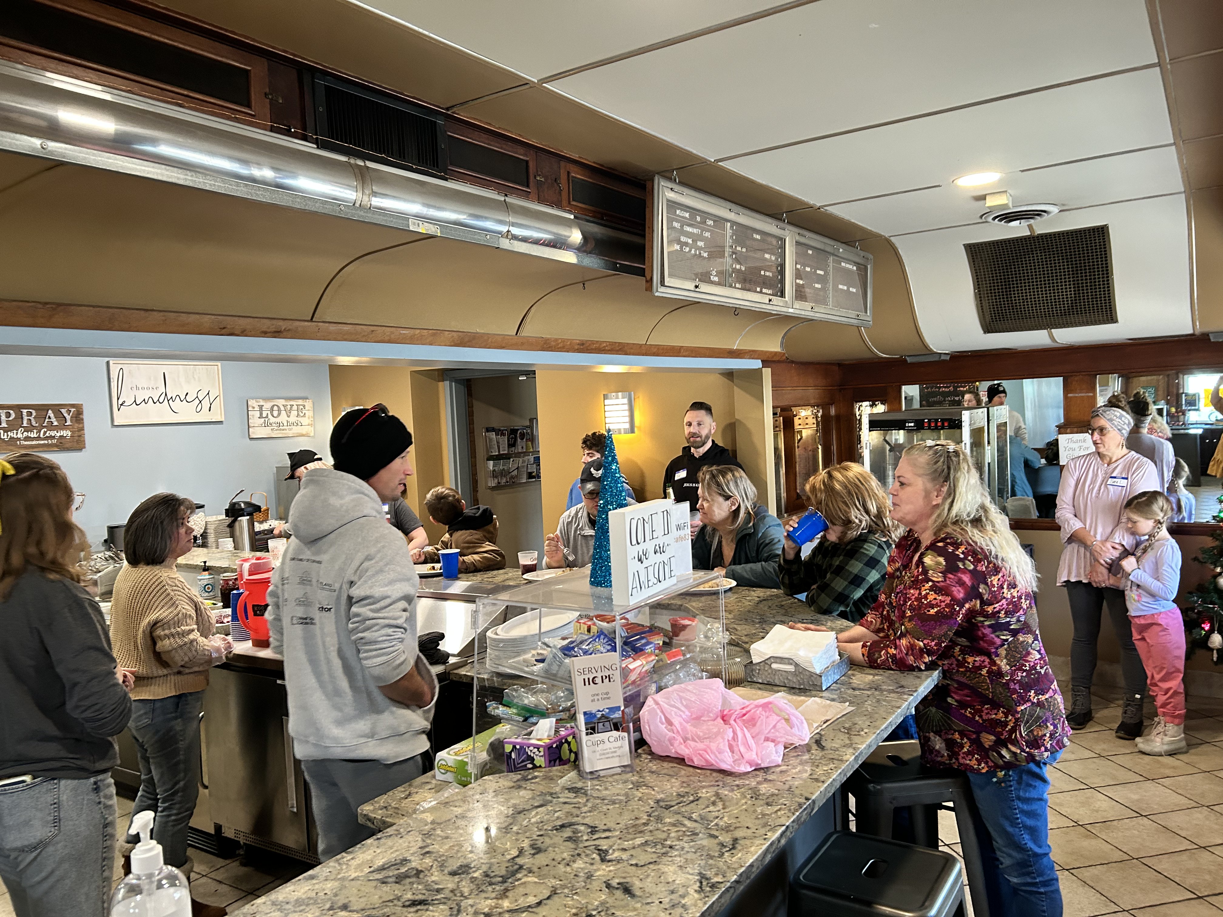 Customers gathered around the Cups Collective cafe counter