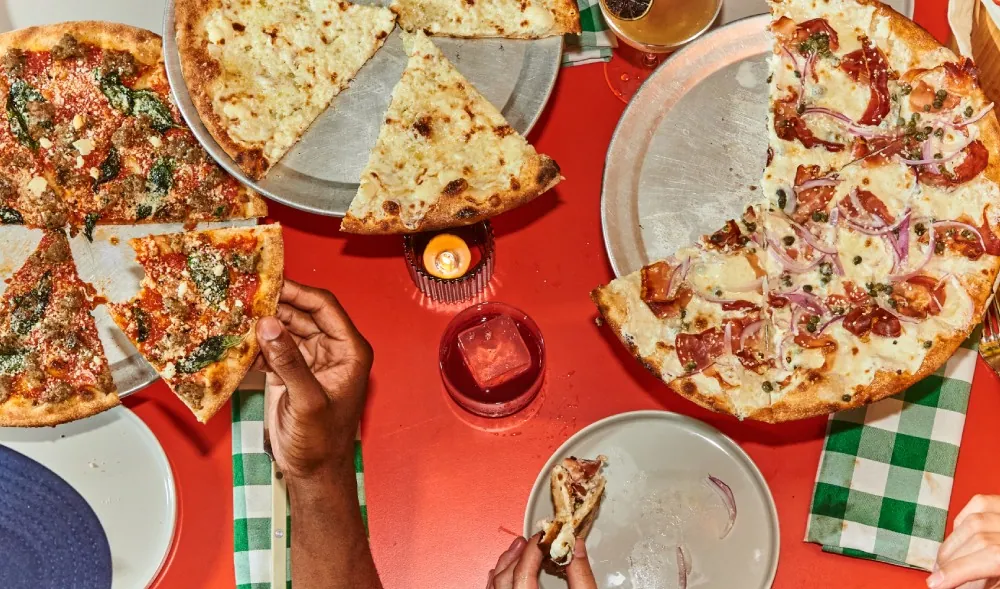 A table of wood-fired pizzas at Cent’s Pizza + Goods