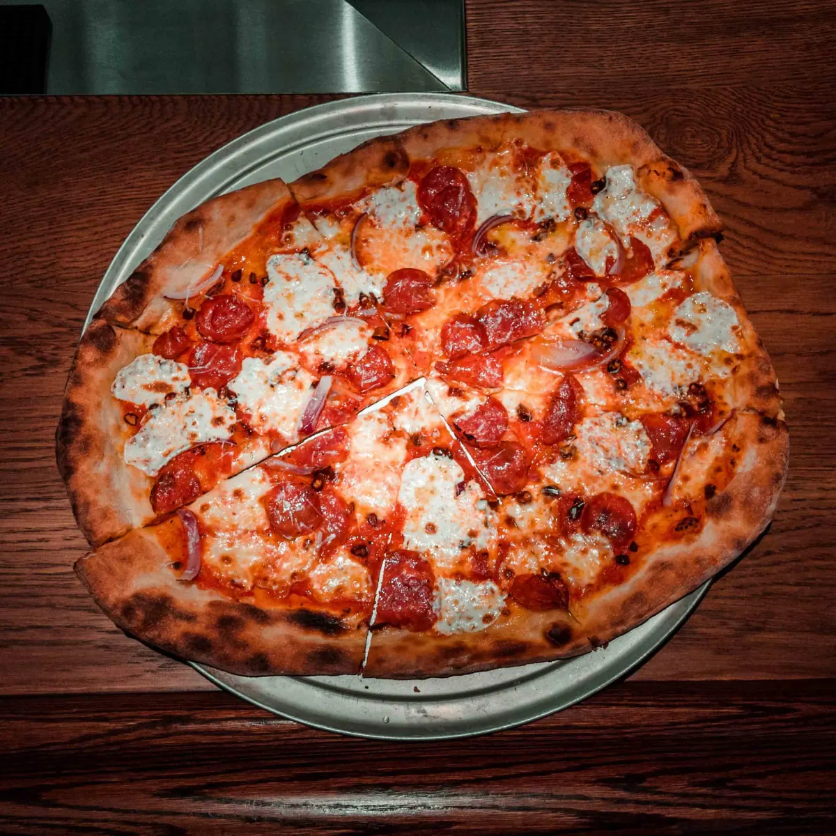 Pepperoni pizza with ricotta and red onion at Il Rione