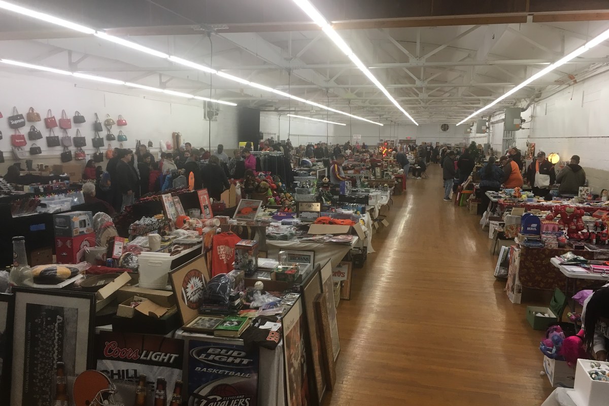 Shoppers browsing rows of vendor tables inside a hall at the Berea Flea Market at the Cuyahoga County Fairgrounds in Berea