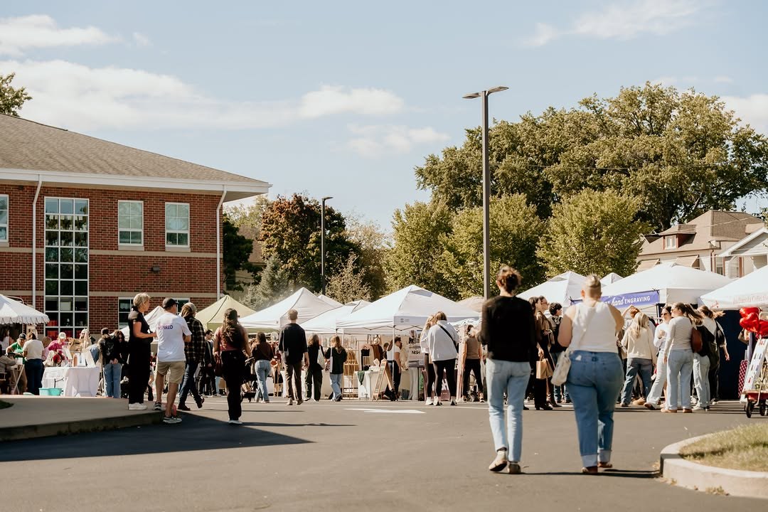 Shoppers walking between vendor tents at Her Market in Lakewood