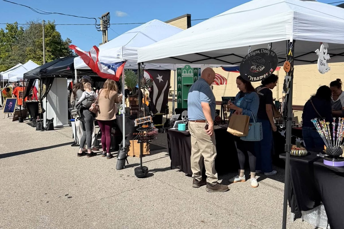 Shoppers browsing vendor tents along the street at the Mill Street Makers' Market in Medina