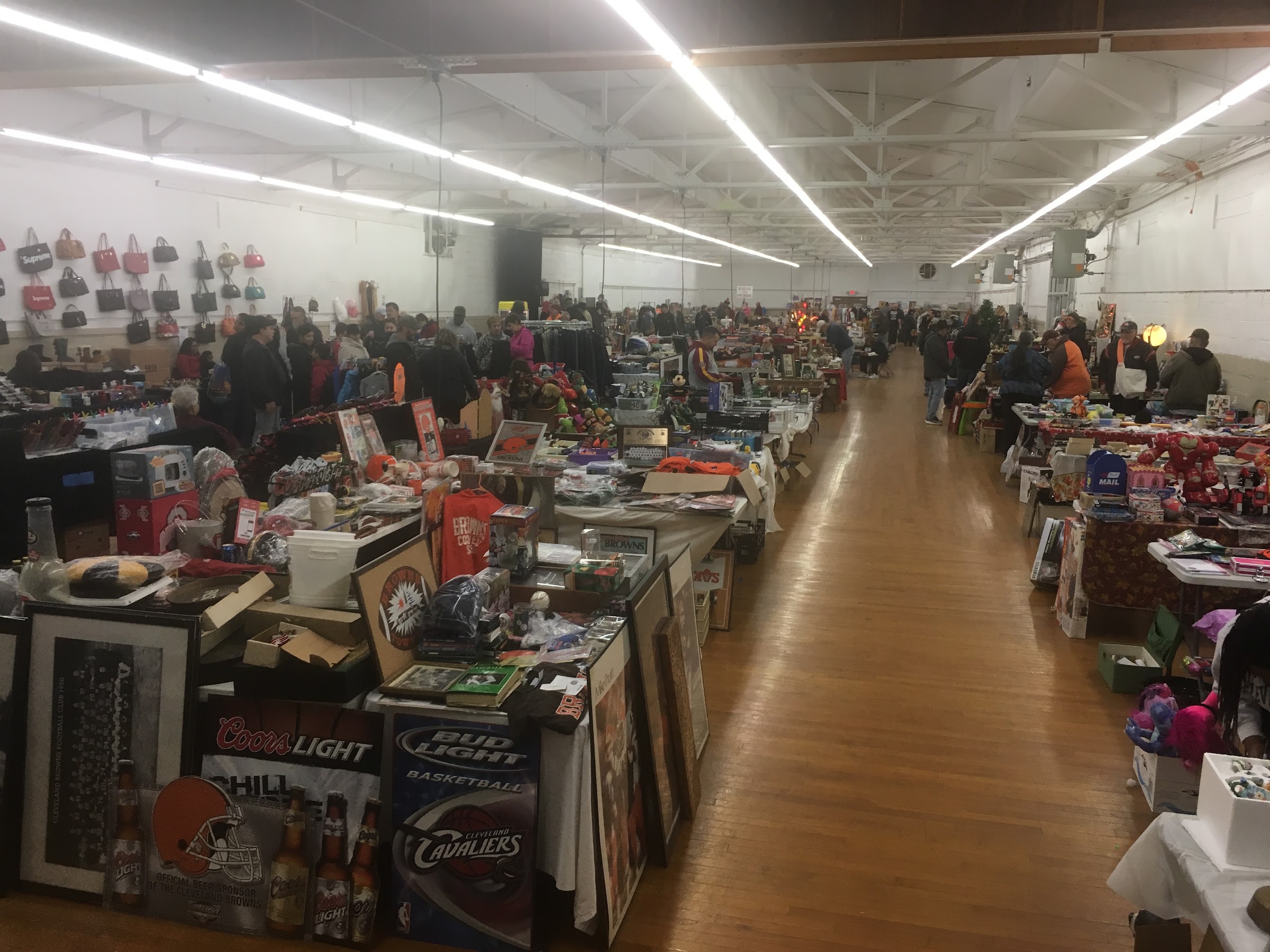 Shoppers browsing rows of vendor tables inside a hall at the Berea Flea Market at the Cuyahoga County Fairgrounds in Berea