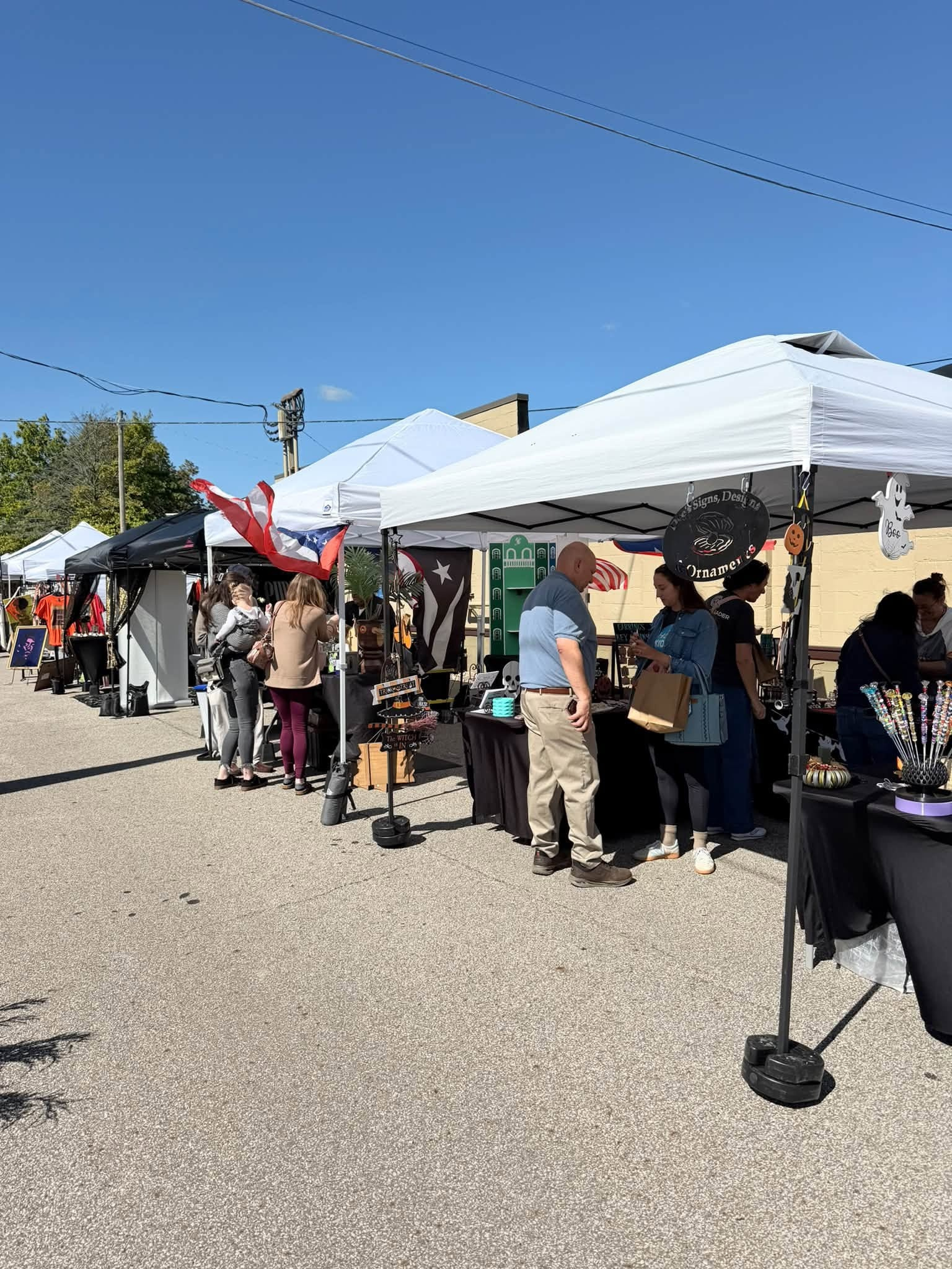 Shoppers browsing vendor tents along the street at the Mill Street Makers' Market in Medina