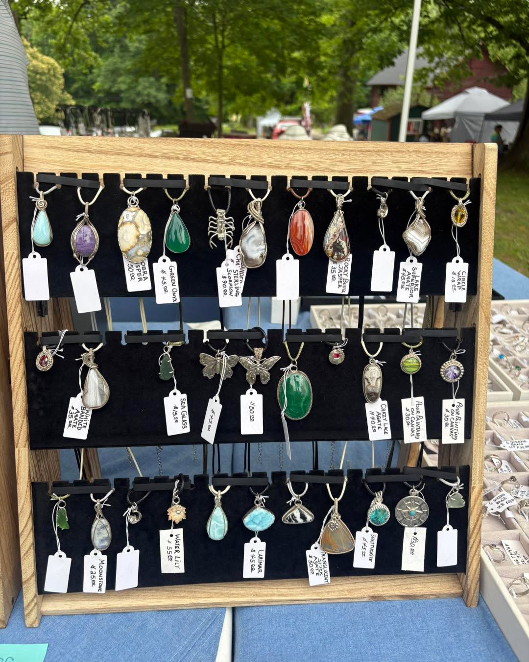 Handmade pendant necklaces on display at a vendor table at the Peninsula Flea at Heritage Farms in Peninsula