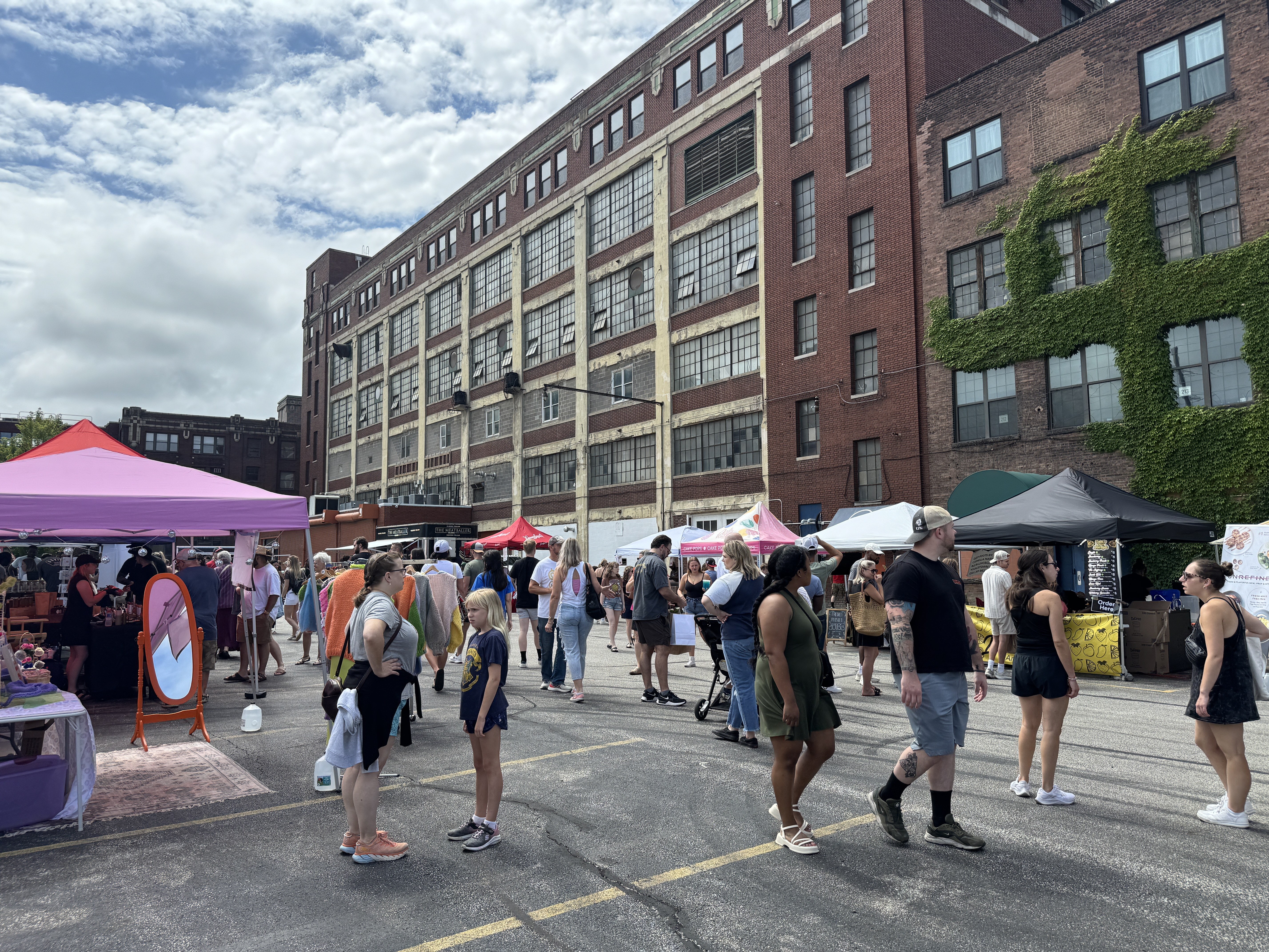 Shoppers browsing vendor tents at The Cleveland Market at Tyler Village in Cleveland on August 3, 2024